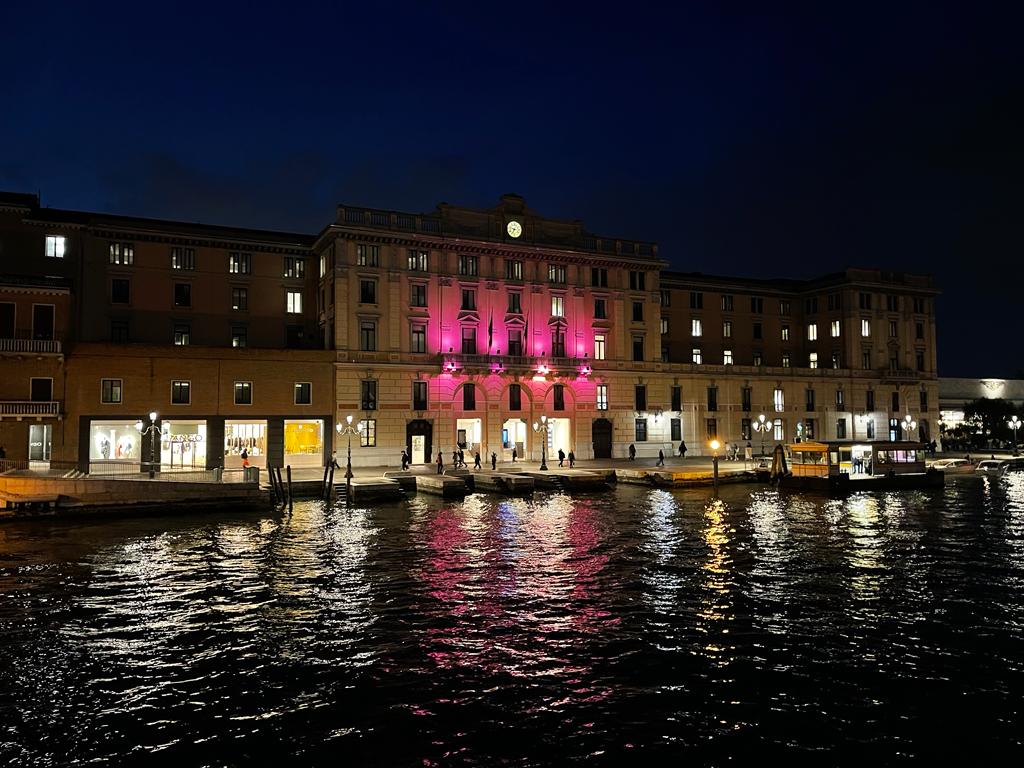 immagine notturna di palazzo Grandi Stazioni a Venezia illuminato di viola