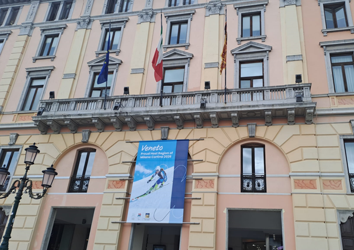 Facciata del Palazzo Grandi Stazioni a Venezia con manifesto dei Giochi Olimpici e Paralimpici Invernali di Milano Cortina 2026