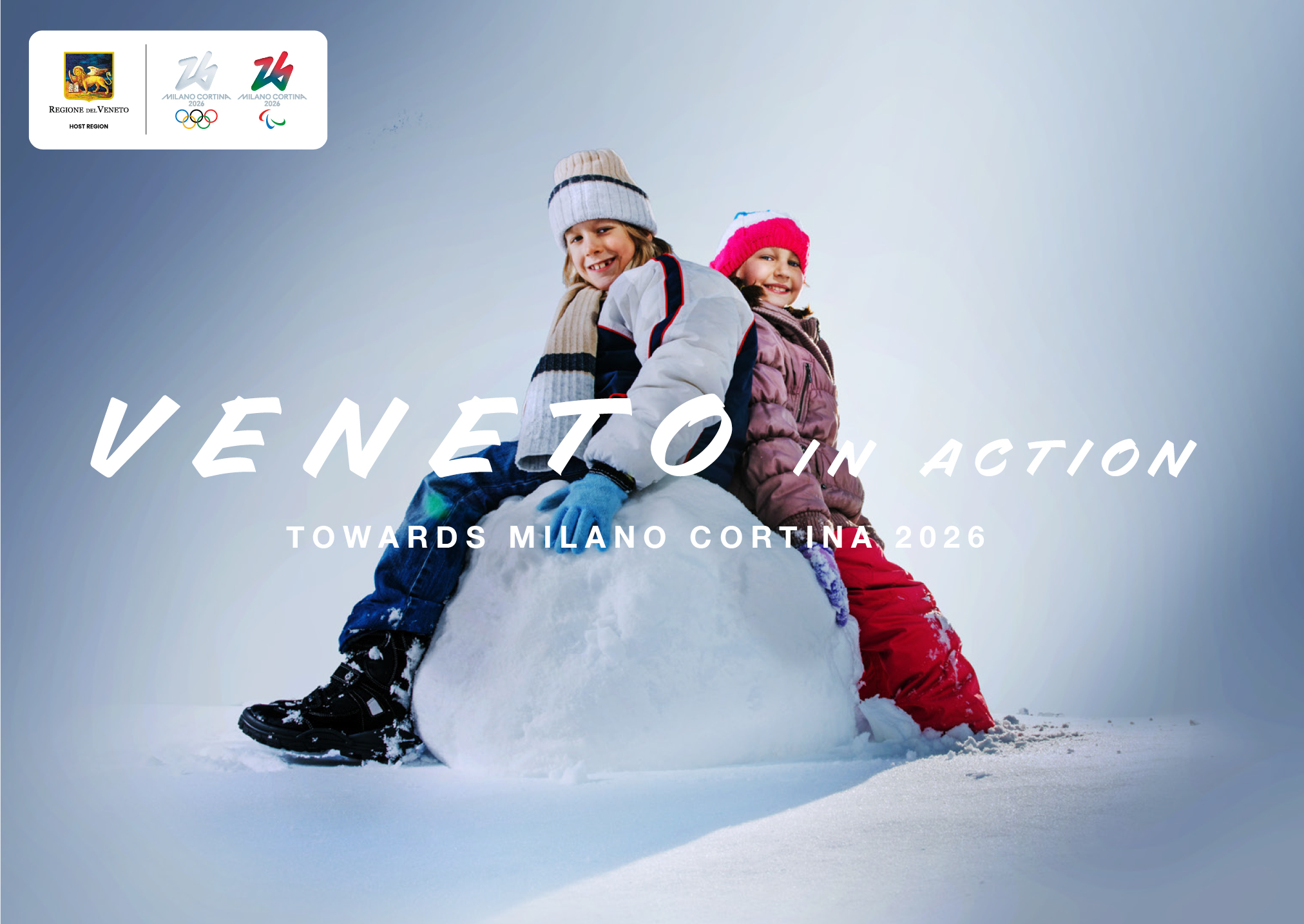 due bambini in abbigliamento da sci seduti su una palla di neve