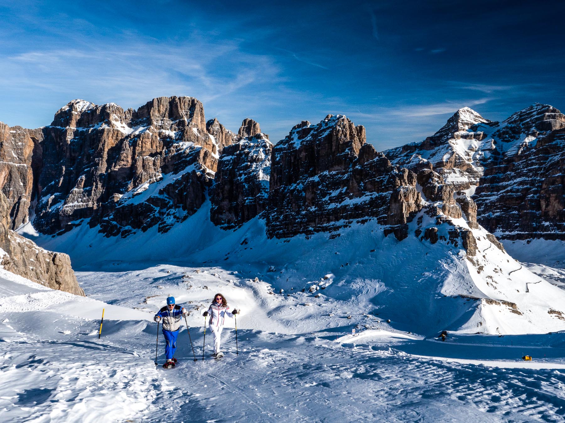 Escursionisti con le ciaspole negli ultimi tratti di salita prima di arrivare alla vetta del Lagazuoi. Vista verso le Torri di Fanes e le Tofane